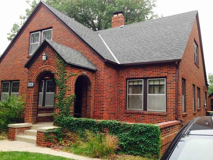 Red brick house with charcoal roof and windows and copper gutters