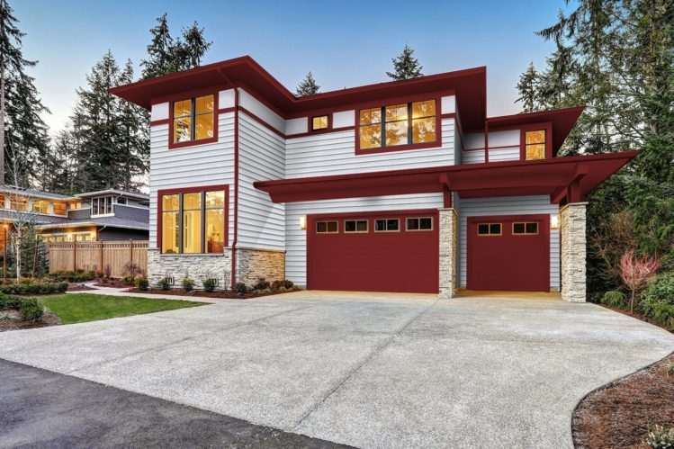 Red framed windows and warm lights on white house 