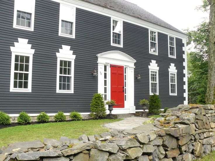 Grey sidling and red front door and white windows
