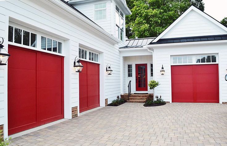 Red garage door on white brick house celling light on the wall 