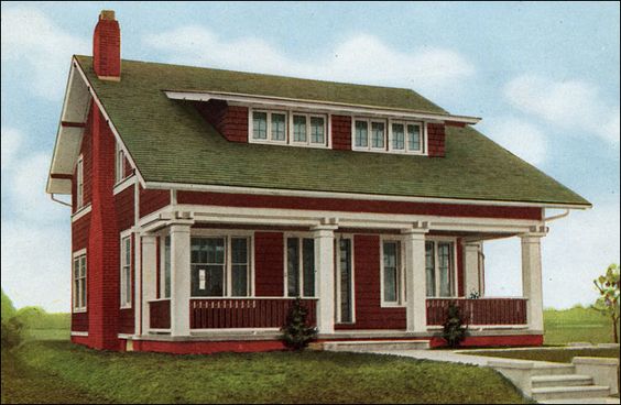 A red hose with green roof and white pilar and windows and glass door and a pathway outside and garden outside of the house