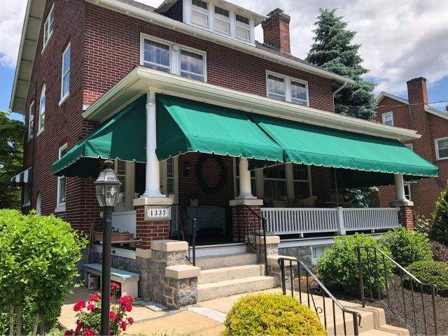 Sage-grey awning with white trim