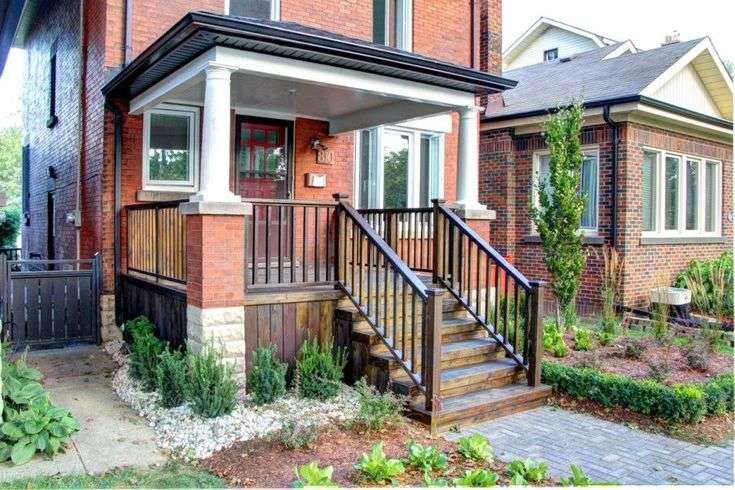 Brick house with staircase with railings and white pillars