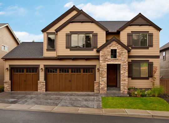 Tan house with brown shutter and wood garage