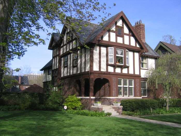 White house with brown beams and garden outside of the house