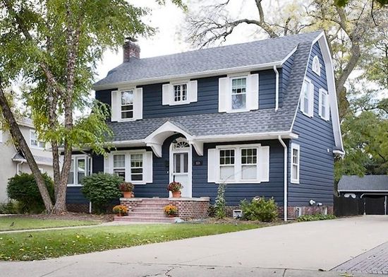 Two tone blue house with shutter and garden outside of the house
