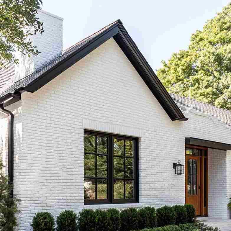 White brick house with black gutters and wooden door