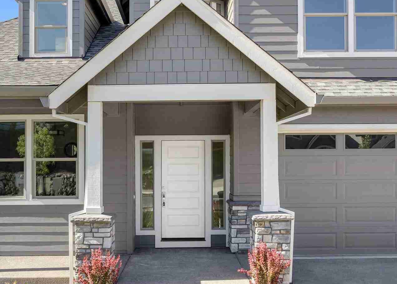 Grey house with white door and white pillar and white framed windows