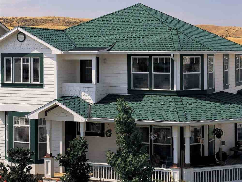 White house with green roof and white trim and white pillar