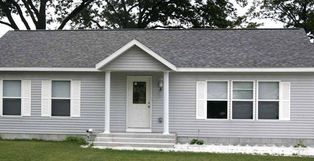 White shutters on grey house and black roof and white door