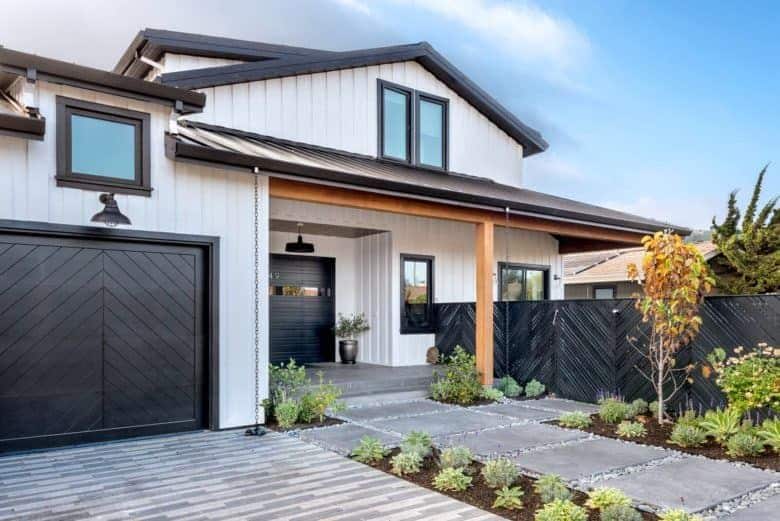 A white house with black windows and black door and garage door