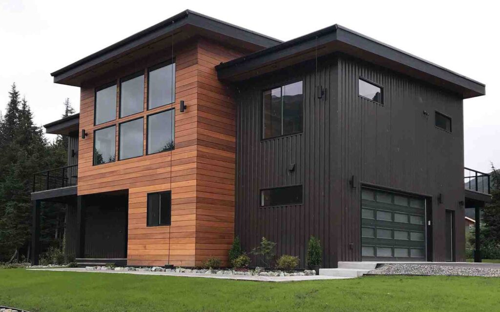 Wood and black shingles and garden outside of the house
