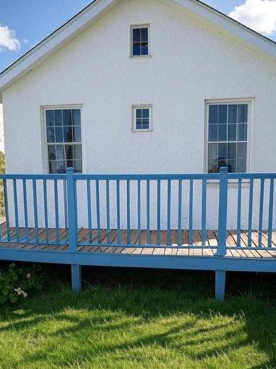 wood decking and blue railing and white house and garden outside of the house