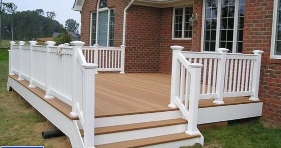 Wooden deck on brick house with white railing