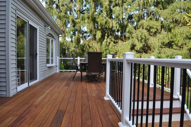 Grey house with wooden decking on the floor and chair and table outside the house