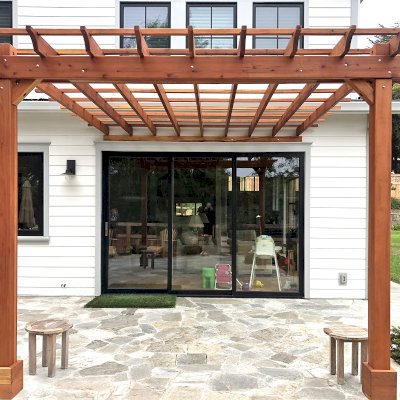 Wooden pergola on white house.