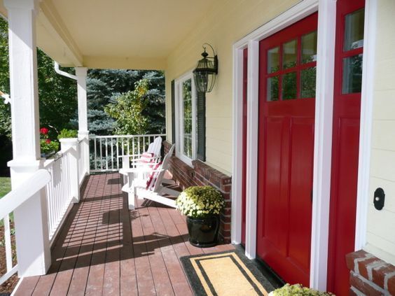 Wooden porch and red door and mat on the floor 