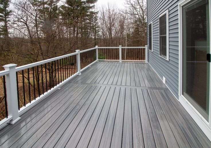 Wooden porch on grey house with with railing