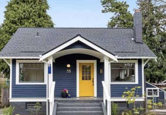 A blue house with yellow front door and white trim