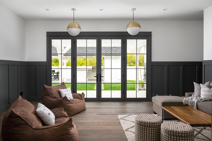 A white wall with board and batten and cushion on the sofa and wooden table
