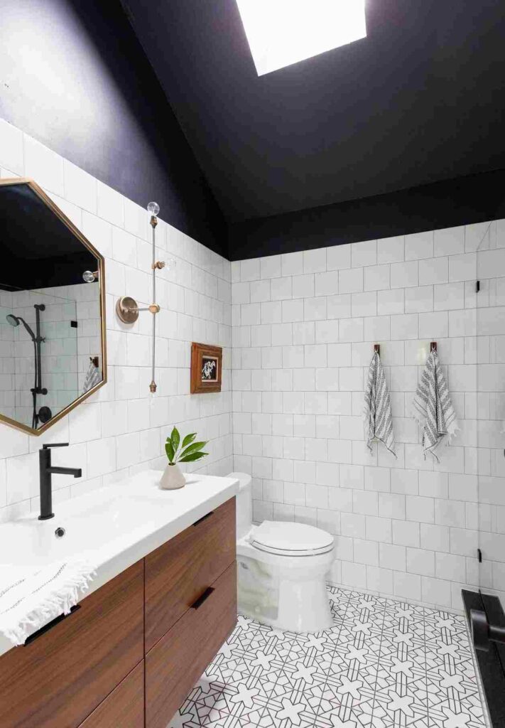A white bathroom with black celling and hooks on wall