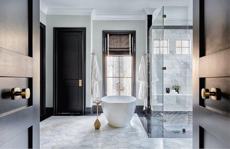 A white bathroom with black door an white bathtub