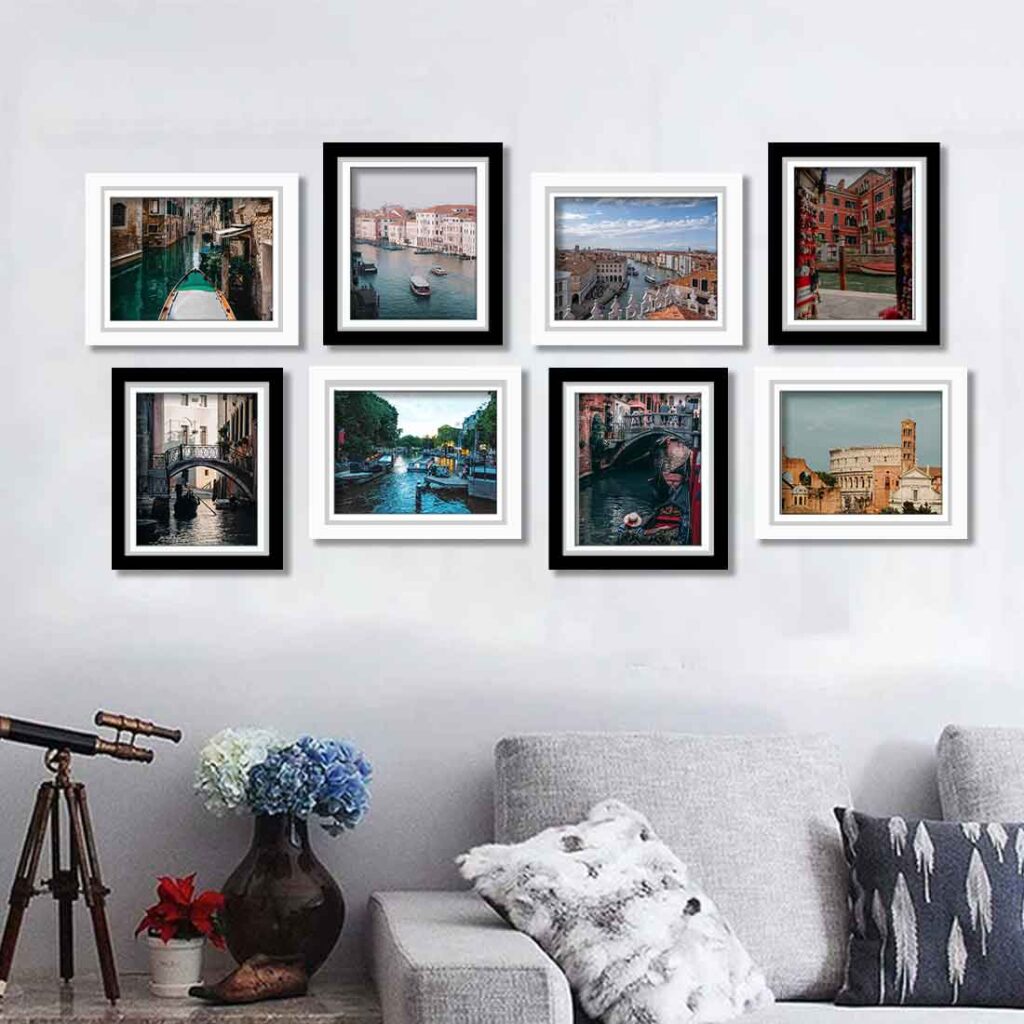 A black framed photo on white wall and grey sofa ad cushion on it 