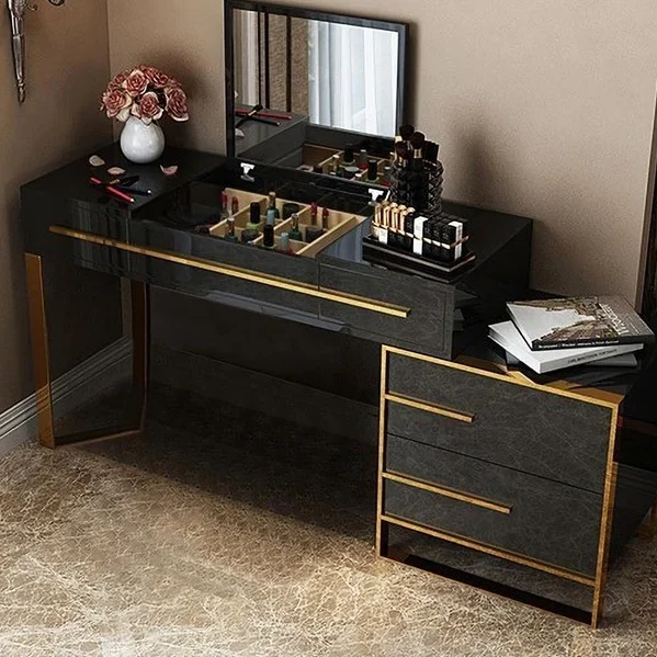 A black vanity with gold accents and black framed mirror