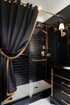 A black bathroom with curtains and gold trim