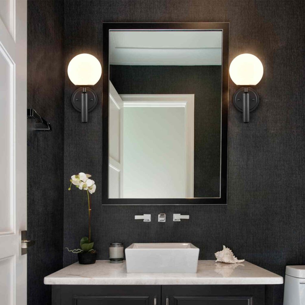 Black wall sconces in black and white bathroom