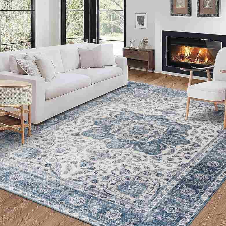 A blue rug in white living room and white sofa and fireplace in thr room
