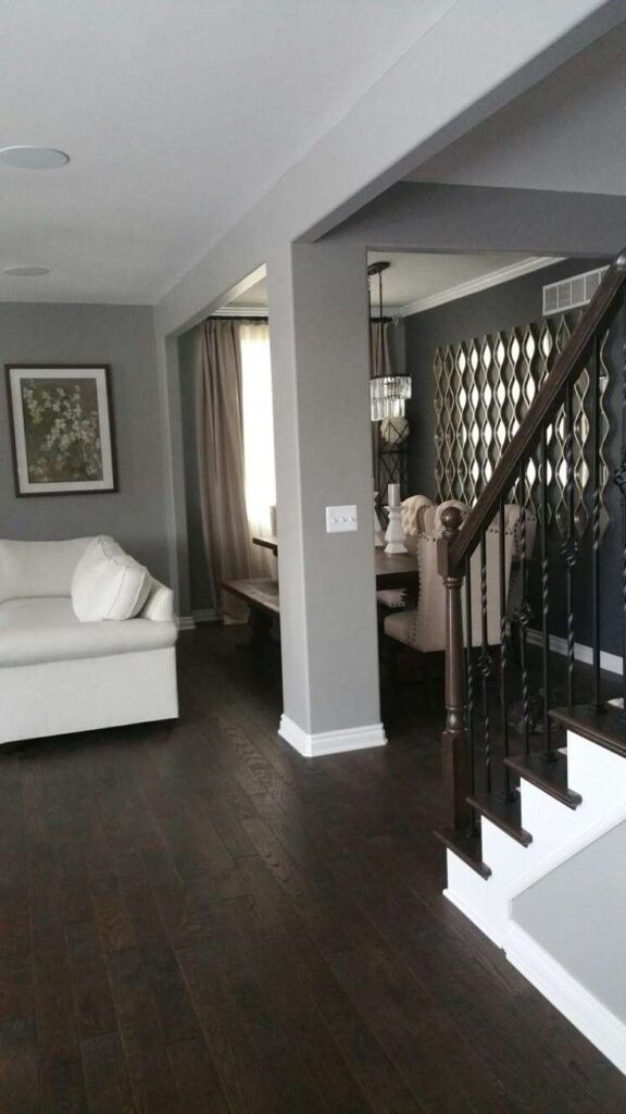 A grey living room with wooden flooring and white sofa