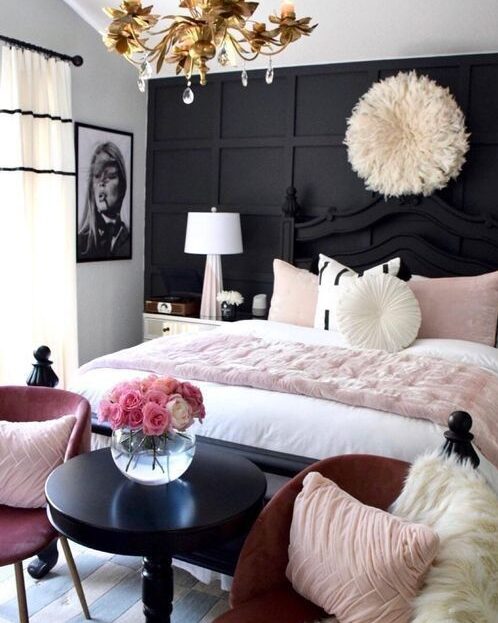 A white and black bedroom with white bed and pink accents 
