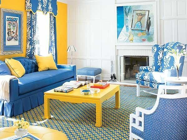 A white with blue and yellow combo living room and yellow table and blue sofa