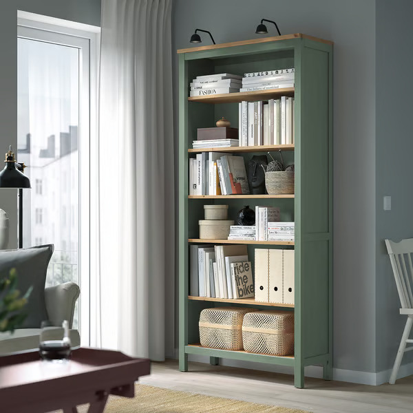 A grey living room with green book shelves