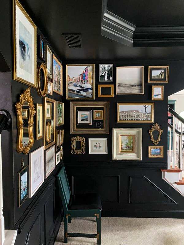 A golden framed photo frames on black wall