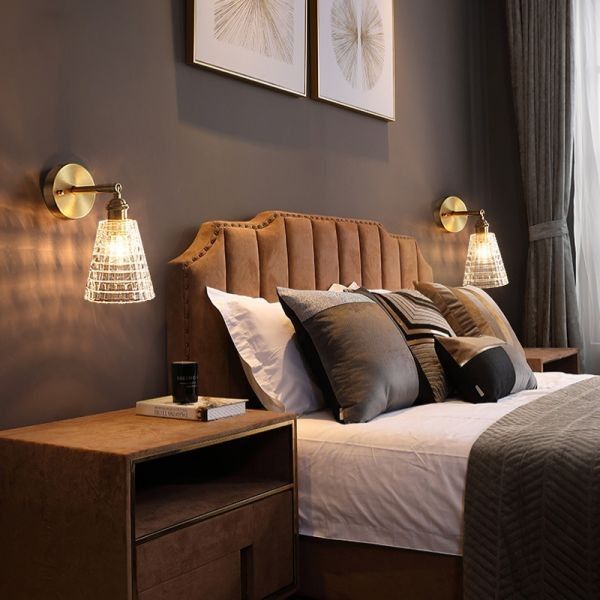 A black bedroom with gold wall sconces