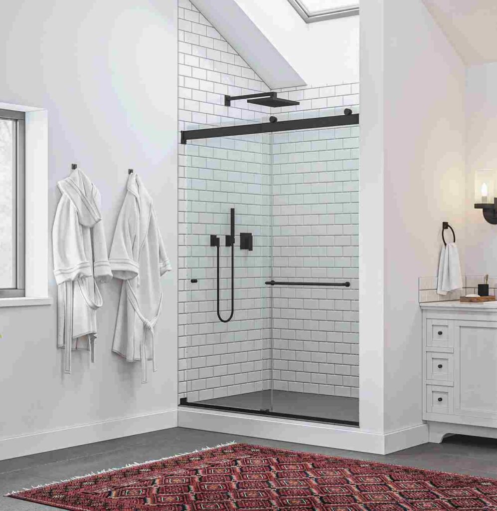 A grey glass door and white bathroom and red mat on the floor