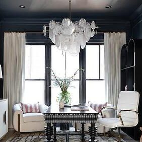 A black wall with white curtain with black road and chair and table 