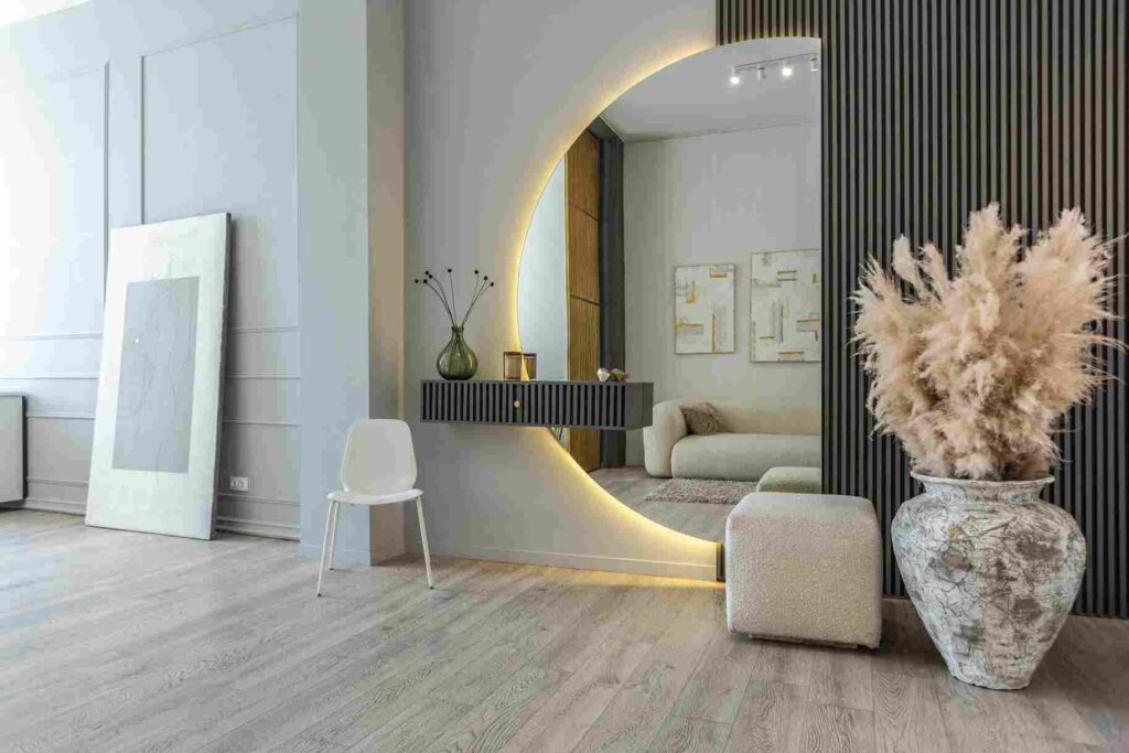 A mirror wall and vase on the side of mirror and wooden floor