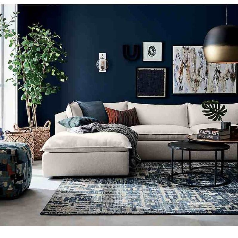A living room with sofa and black table and woven basket