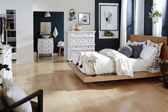 A white and black bedroom with wooden floor and white dreeser 