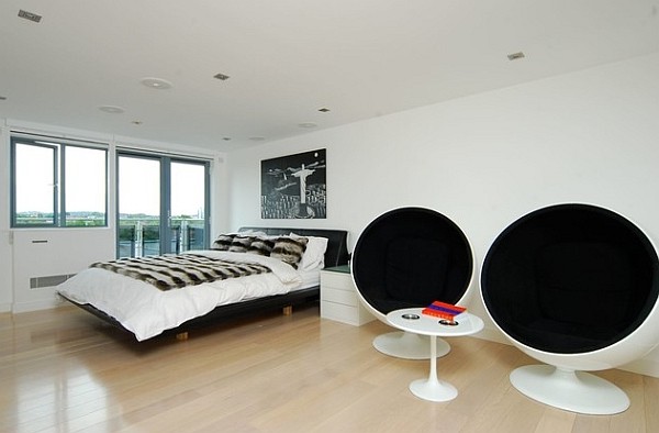 A white bedroom and two boll chairs and bed and glass windows and wooden floor 