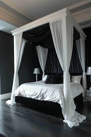 White canopy bed in black bedroom.