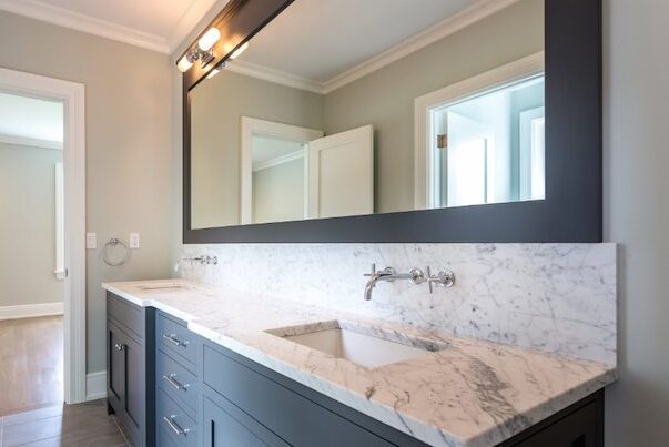 A white bathroom with grey vanity with white marble  contertop