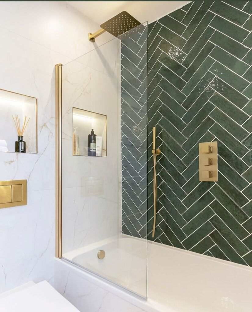 A green bathroom with tiles and gold accents 