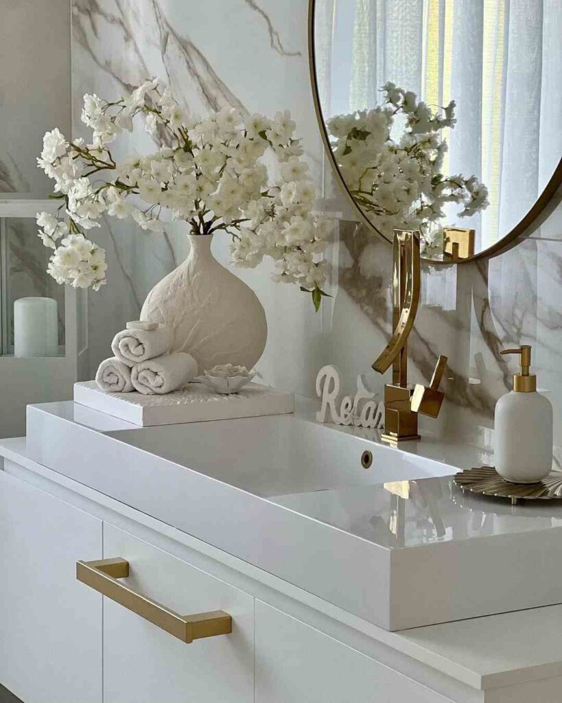 A  white bathroom white vase and mirror on the wall 