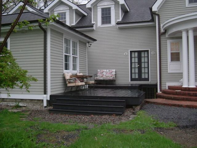 A black decking on the grey house with grey house