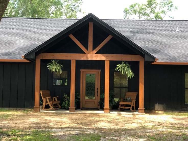 A black house with cedar pillars and gable roof