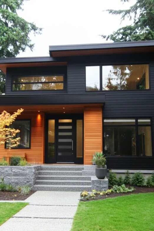 A black house with cedar accents and black glass door and windows